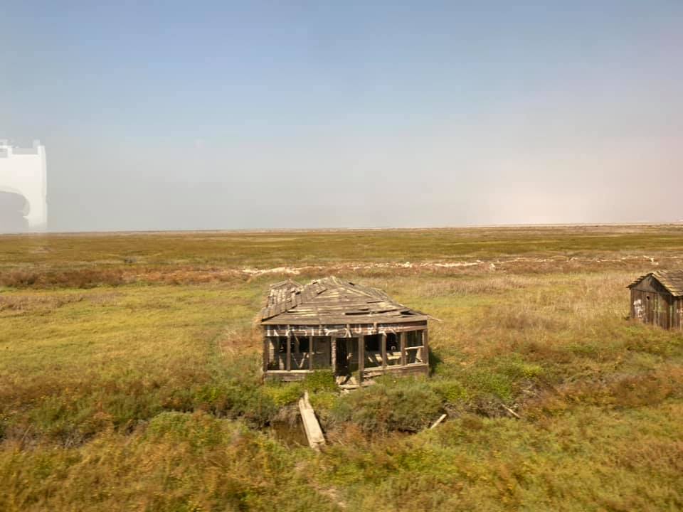 an old abandoned house in a grassy field